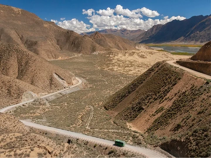 A road winding through the mountains in the middle of a valley