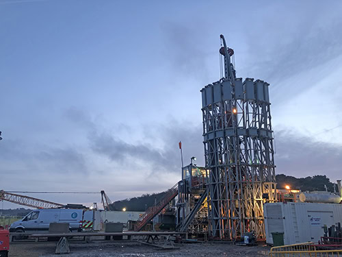 A large drilling rig is in the middle of a field